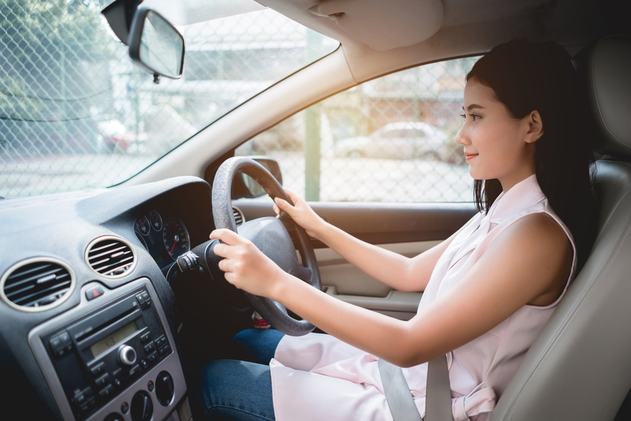 Woman driving car in front seat and looking ahead
