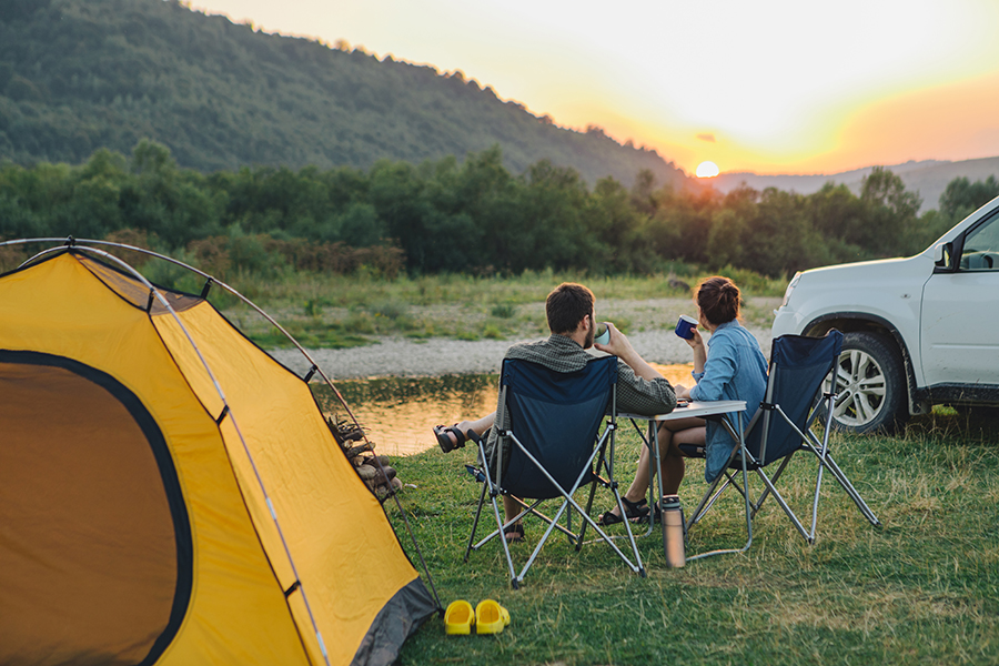 Couple sitting on camp chairs.