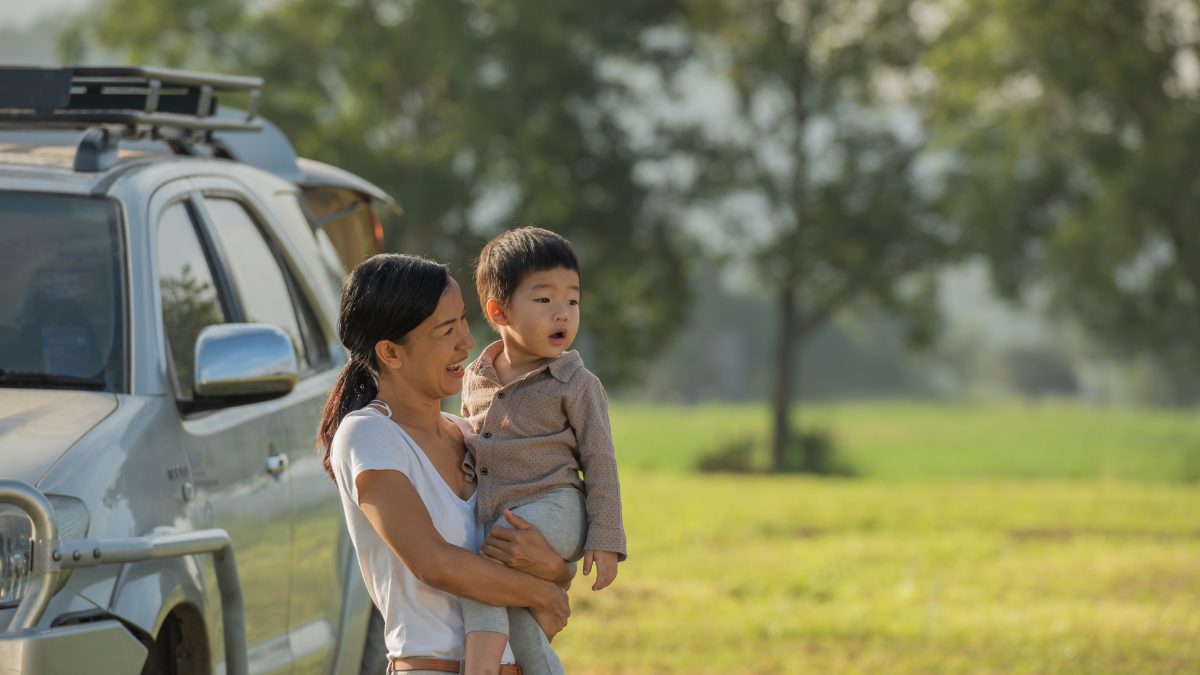 camping with kids. happy mother and son with spending time outdoor in the autumn park. we like autumn time together. first memories. family having a picnic beside their camper car.