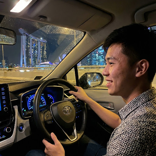 young singaporean driver smiling in the car